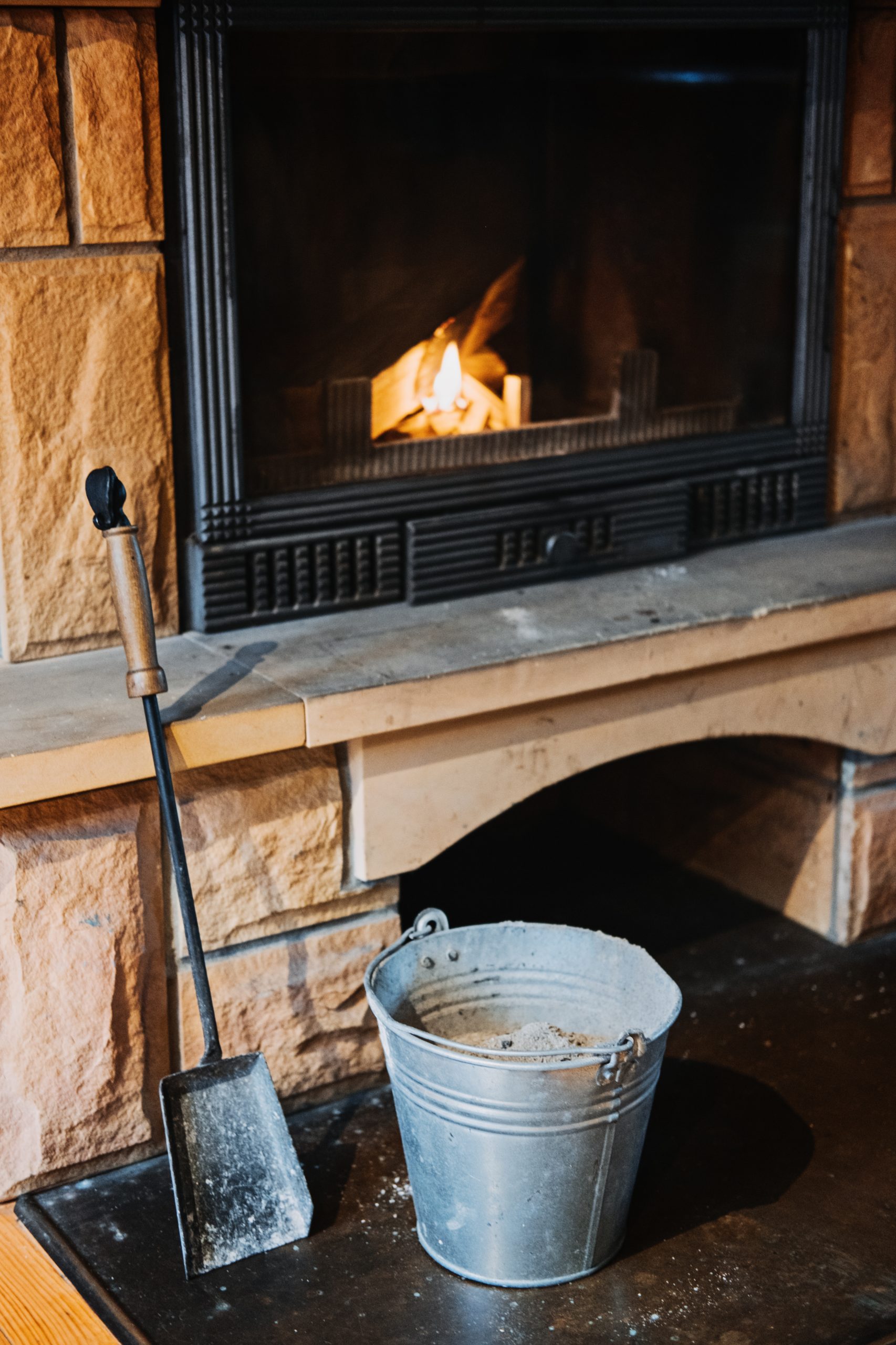How to Remove Wood Ashes In Fireplace, How To Properly Clean Ashes Out Of Home Fireplace. Cleaning fireplace with open tray. Fireplace, wicker basket for firewood, pile of logs for a fire.